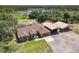 Breathtaking aerial view showcasing a pool, brick home, covered parking, outbuildings, and a tranquil lake surrounded by lush landscape at 685 Enterprise Osteen Rd, Osteen, FL 32764