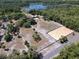 Expansive aerial view of a property with a horse arena, home, and tranquil lake amid lush greenery at 685 Enterprise Osteen Rd, Osteen, FL 32764