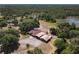 Estate aerial view of home and acreage with outbuildings, a pond, and lush greenery at 685 Enterprise Osteen Rd, Osteen, FL 32764