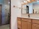 Bathroom featuring a granite-style shower stall with built-in shelving and a vanity with traditional faucets and lighting at 685 Enterprise Osteen Rd, Osteen, FL 32764