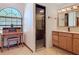 This bathroom showcases a wooden vanity, glass shower, and unique desk space next to a curved window at 685 Enterprise Osteen Rd, Osteen, FL 32764