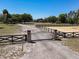 View of a gated entrance to the property with a long driveway leading to the house and arena at 685 Enterprise Osteen Rd, Osteen, FL 32764