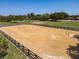 A large equestrian sand arena with wooden perimeter fence and horse riding poles on a sunny day at 685 Enterprise Osteen Rd, Osteen, FL 32764