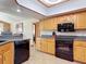 Traditional kitchen featuring wood cabinets, modern black appliances and tile flooring at 685 Enterprise Osteen Rd, Osteen, FL 32764