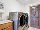 Modern laundry room featuring a sink, modern washer and dryer set, and an exterior access door at 685 Enterprise Osteen Rd, Osteen, FL 32764