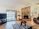 Cozy living room featuring a brick fireplace and sliding glass doors to the pool area at 685 Enterprise Osteen Rd, Osteen, FL 32764