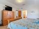 Comfortable main bedroom featuring a dresser with a television and a bed with a seashell-themed comforter at 685 Enterprise Osteen Rd, Osteen, FL 32764