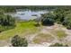 Scenic pond view featuring lush greenery, lily pads, and a mix of sandy and grassy areas at 685 Enterprise Osteen Rd, Osteen, FL 32764