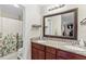 Charming bathroom with a double vanity, granite countertop, and shower-tub combo with decorative curtain at 732 Mockingbird Ln, Deland, FL 32720