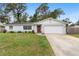 Charming single-story home showcasing well-maintained landscaping and a classic red door at 732 Mockingbird Ln, Deland, FL 32720