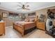 Cozy main bedroom featuring a ceiling fan, neutral tones, a wood bed frame, and natural light at 795 Superior St, Deltona, FL 32725