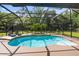 Relaxing screened-in pool area featuring lush landscaping and lounge seating at 795 Superior St, Deltona, FL 32725