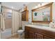 Well-lit bathroom with a shower, vanity, large mirror, and wood-look flooring at 800 Hidden Oaks Ln, Oak Hill, FL 32759