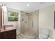 Bathroom featuring a glass shower with tile accents, a modern sink, and a toilet at 800 Hidden Oaks Ln, Oak Hill, FL 32759