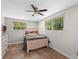 Bedroom with wood floors, ceiling fan, and natural light streaming through the windows at 800 Hidden Oaks Ln, Oak Hill, FL 32759