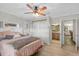 Bedroom with a ceiling fan, closet, ensuite bathroom, and wood-look flooring at 800 Hidden Oaks Ln, Oak Hill, FL 32759