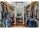 Walk-in closet with rows of clothes and shoes, with a view from the window offering natural lighting at 800 Hidden Oaks Ln, Oak Hill, FL 32759