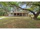 The exterior features a covered front porch and beautiful trees at 800 Hidden Oaks Ln, Oak Hill, FL 32759