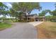 Charming home with a porte cochere and lush landscaping, nestled under mature trees at 800 Hidden Oaks Ln, Oak Hill, FL 32759
