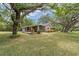 The exterior features a covered front porch and a lush green lawn at 800 Hidden Oaks Ln, Oak Hill, FL 32759
