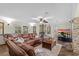 Bright living room with tile floors, fireplace, and leather couch at 800 Hidden Oaks Ln, Oak Hill, FL 32759