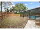 Large backyard featuring a screened-in pool, complemented by a spacious lawn and wood fence at 808 Jutland St, Deltona, FL 32725