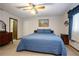 Cozy bedroom featuring a ceiling fan, blue bedspread and wood furniture at 808 Jutland St, Deltona, FL 32725