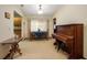 Cozy dining room with a wooden table and chairs set next to a large piano and bright window at 808 Jutland St, Deltona, FL 32725