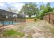 Backyard featuring a screened-in pool area, surrounded by a spacious yard and a wood fence at 808 Jutland St, Deltona, FL 32725