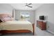 Cozy bedroom features a four-poster bed and scenic window view of a pond at 811 Grand Park Ct, Deland, FL 32724