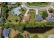 Aerial view of a single-Gathering home with lush greenery, a nearby pond, and a defined property line at 823 Wooddusk Dr, Port Orange, FL 32127