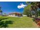 Backyard view with the screened-in lanai, lush grass, and access to a serene pond at 823 Wooddusk Dr, Port Orange, FL 32127