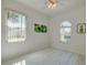Well-lit bedroom with two windows, ceiling fan, and light wood-look floors at 823 Wooddusk Dr, Port Orange, FL 32127