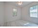 Bright bedroom with two windows, a ceiling fan, and white wood-look flooring at 823 Wooddusk Dr, Port Orange, FL 32127