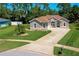 Well-maintained front lawn of a single-story home with a paved driveway and decorative landscaping at 823 Wooddusk Dr, Port Orange, FL 32127