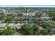 Expansive aerial view of a neighborhood with mature trees and a lake in the distance at 825 Baltimore Dr, Orlando, FL 32810