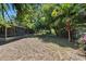 Spacious backyard with a screened porch, mature trees, and ample space for outdoor activities at 825 Baltimore Dr, Orlando, FL 32810