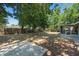 Wooded backyard with a concrete patio, a screened porch, and mature trees providing shade at 825 Baltimore Dr, Orlando, FL 32810