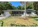 Charming single-story home with a screened porch, attached garage, and lush landscaping at 825 Baltimore Dr, Orlando, FL 32810