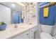 Well-lit bathroom with white cabinets, shelves, and blue accents at 89 S Atlantic Ave # 505, Ormond Beach, FL 32176