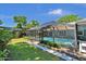 Manicured backyard featuring screened in-ground pool, landscaping, and stone paver walkway at 1 Cobblestone Trl, Ormond Beach, FL 32174