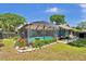 Beautiful in-ground pool featuring a screened enclosure, backyard landscaping and walkway at 1 Cobblestone Trl, Ormond Beach, FL 32174