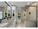 This bathroom features double sinks, granite countertop, walk-in shower with glass door and natural lighting at 1 Cobblestone Trl, Ormond Beach, FL 32174