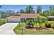Charming ranch-style home featuring a well-manicured lawn and mature palm trees at 1 Cobblestone Trl, Ormond Beach, FL 32174