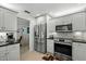 Modern kitchen with stainless steel appliances, white cabinets, and a stylish backsplash at 1 Cobblestone Trl, Ormond Beach, FL 32174