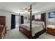 Spacious main bedroom features four-poster bed, ceiling fan, and glass doors to the pool area at 1 Cobblestone Trl, Ormond Beach, FL 32174