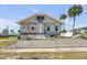 Front view of a home with peeling paint and palm trees, showing potential for renovation at 101 Egret Ave, Port Orange, FL 32127