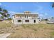 View of a two-story home with exterior showing peeling paint and cinder block foundation at 101 Egret Ave, Port Orange, FL 32127