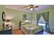 Bedroom features green walls, a ceiling fan, window and bed covered in green and white linens at 104 Nathan Hale Ct, Daytona Beach, FL 32119