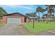 Charming single-story brick home with lush lawn, mature palm trees and attached two-car garage at 104 Nathan Hale Ct, Daytona Beach, FL 32119